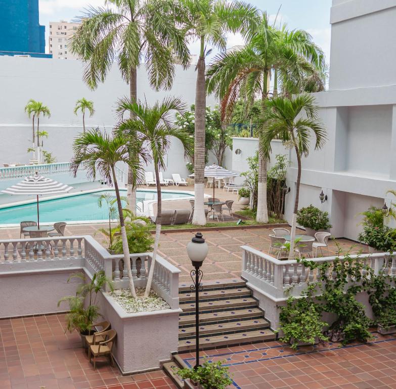 巴兰基亚Hotel Faranda Express Puerta Del Sol Barranquilla, A Member of Radisson Individuals的棕榈树和游泳池度假村