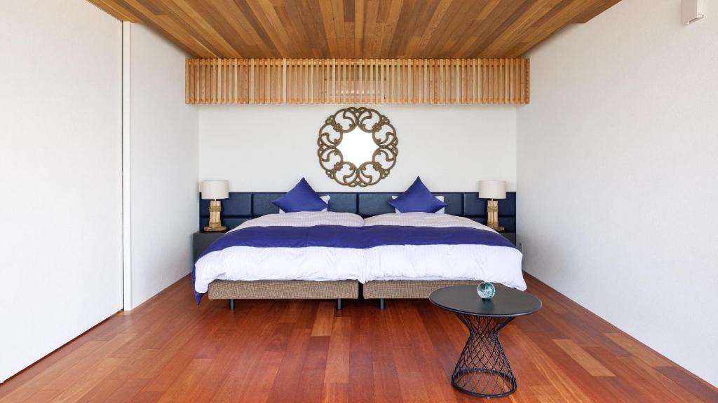 米子市Soukyu 蒼穹 #TB1的卧室配有蓝色和白色的床和一张桌子