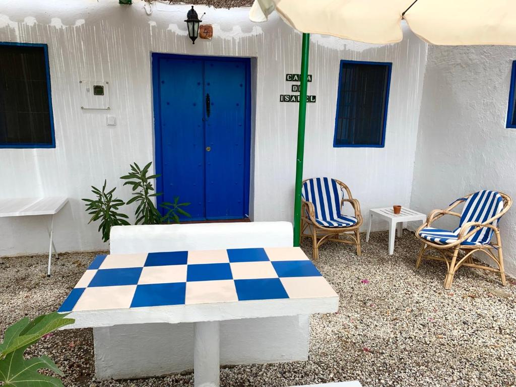 埃尔乔罗伊莎贝尔阿尔蒙纳奇卡民宿的庭院配有桌椅和遮阳伞。