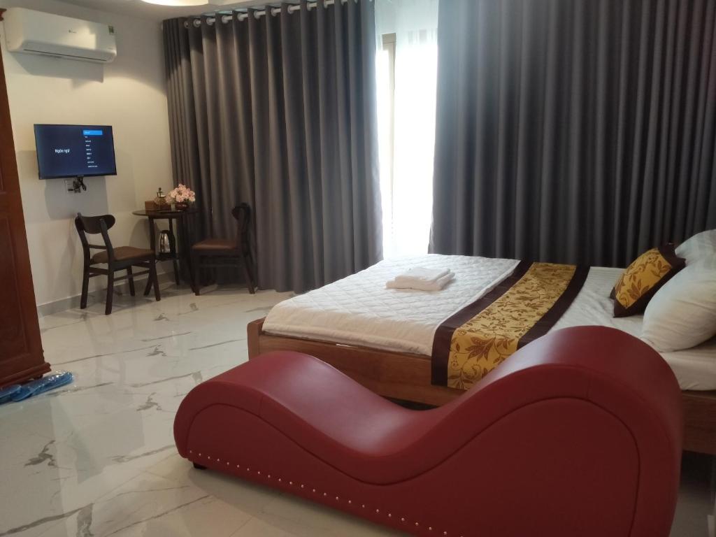 Dĩ AnKhách sạn KEN HOTEL DĨ AN的一间卧室设有两张床,里面设有红色长凳。