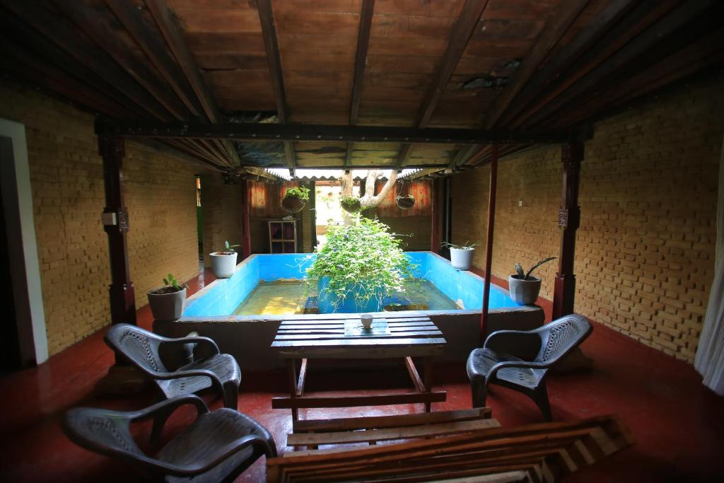 锡吉里亚Sigiri Peace Hostel的客房设有带2把椅子和1张桌子的游泳池。