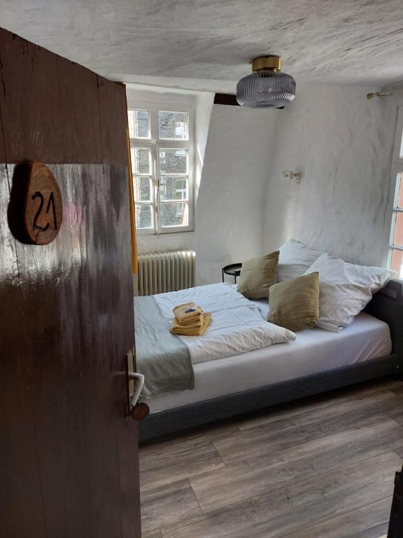蒙绍ReSt Inn Monschau的一间卧室配有一张带白色床单的大床
