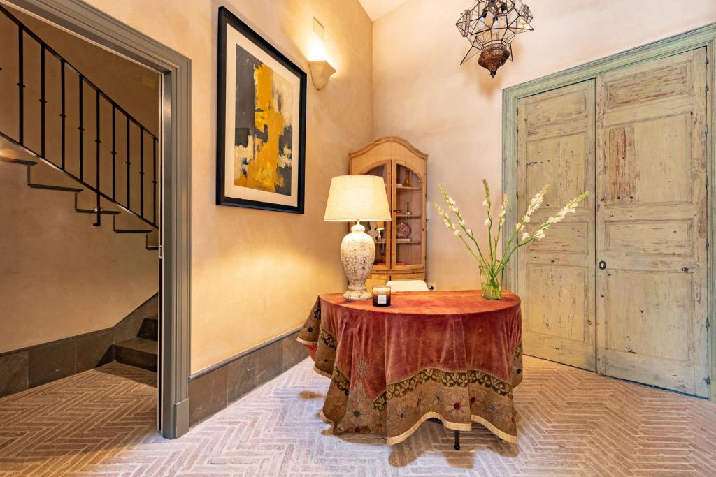 塞维利亚Casa de la Moneda Residences Sevilla的一间房间,桌子上放着一盏灯