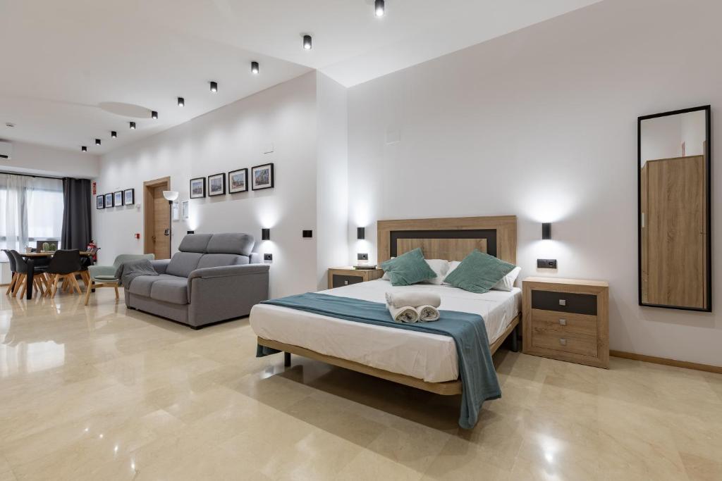 瓦伦西亚Travel Habitat La Marina Real的一间卧室设有一张床和一间客厅。