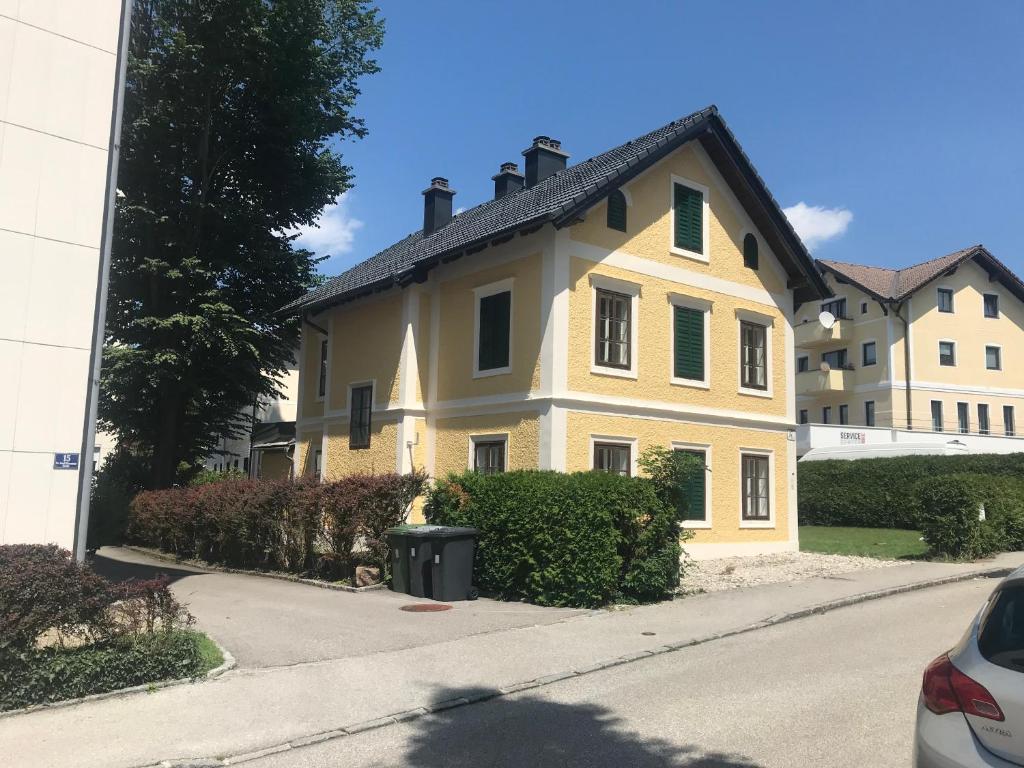 格蒙登Haus Traundorf的街上有绿色百叶窗的黄色房子