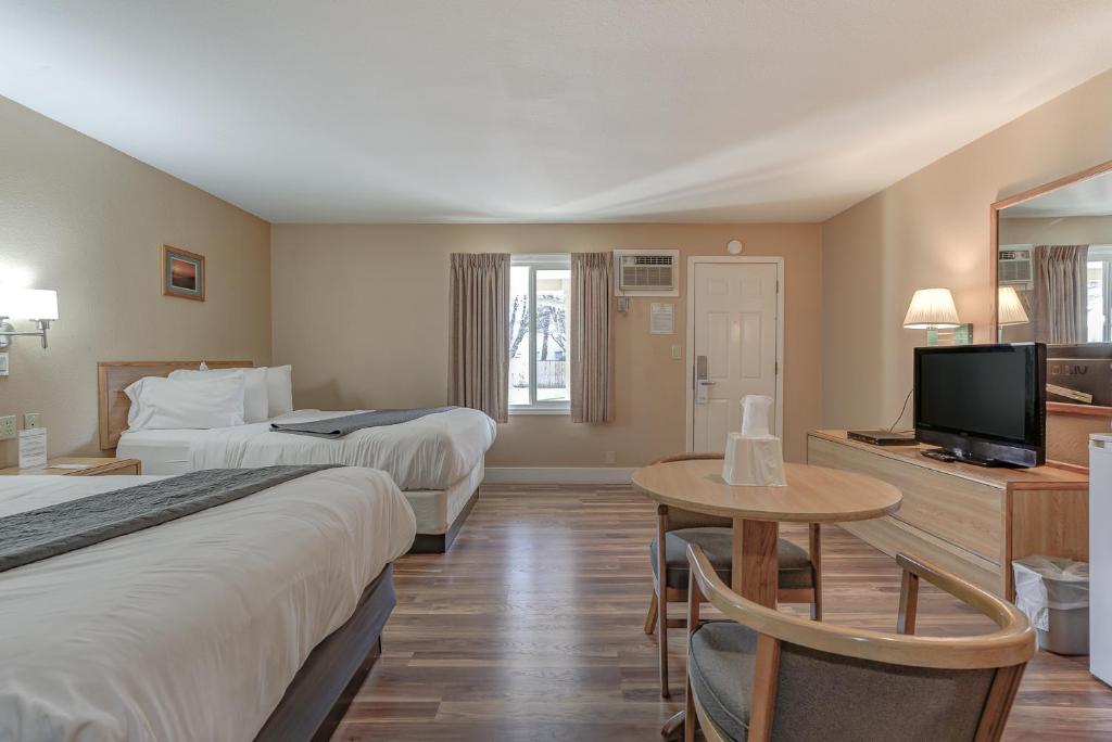 BurneyShasta Pines Motel &amp; Suites的有两张床和一台电视的酒店房间