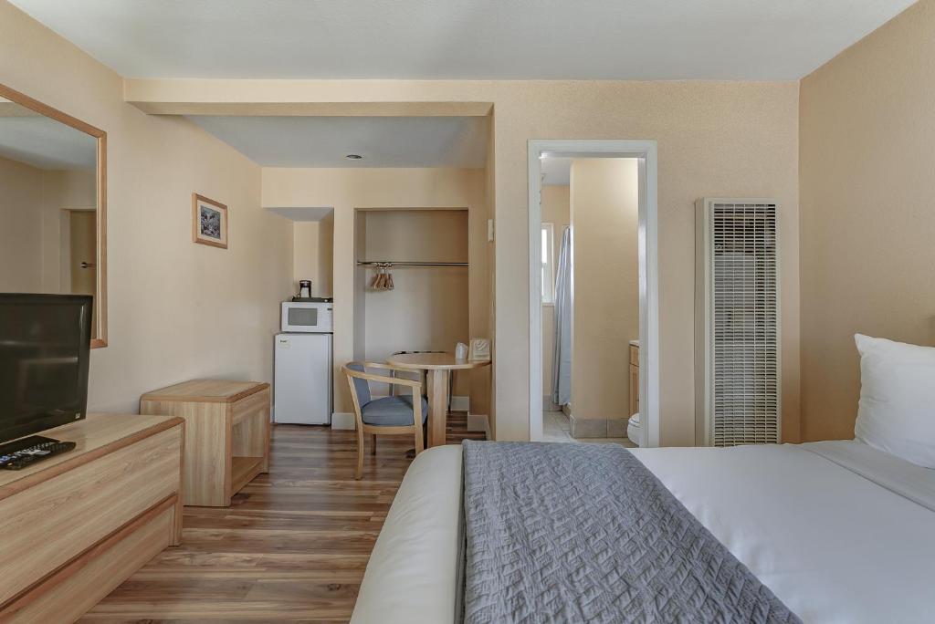 BurneyShasta Pines Motel &amp; Suites的一间带床和厨房的酒店房间