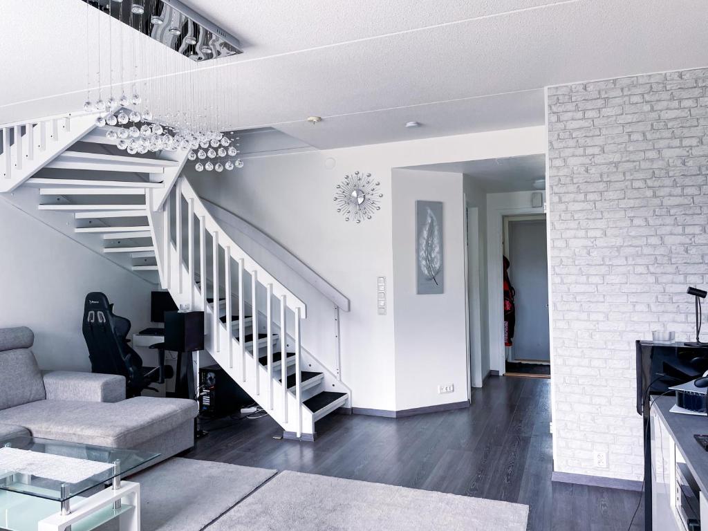于韦斯屈莱Avara, ylellinen kaksikerroksinen huoneisto.的客厅拥有白色的墙壁和楼梯