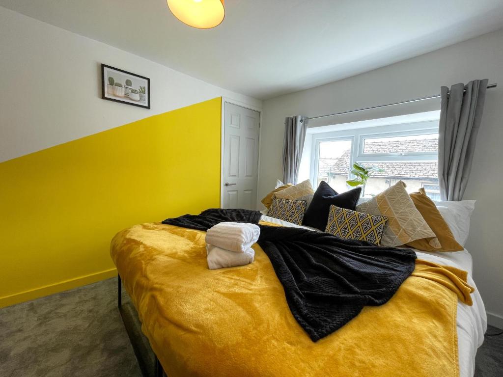 NantygloHeritage House By MGroupSA - Free Parking的一间卧室设有一张黄色墙壁的大床
