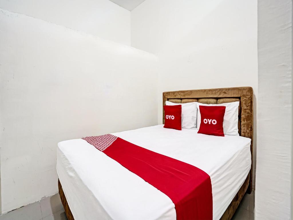 LamonganGrand Hagawa Syariah near Alun Alun Lamongan RedPartner的一间卧室配有一张带两个红色枕头的床