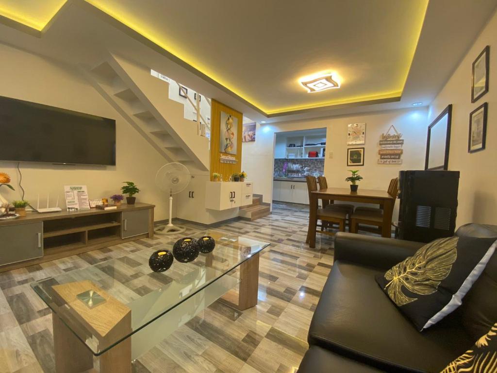 MalabañasMAJESTIC 2 BR TOWNHOUSE - near AQUA PLANET & CLark Airport - TRP8的带沙发、电视和桌子的客厅