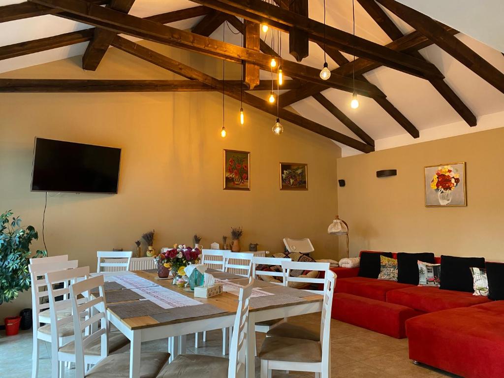 StremţAgropensiunea Colev的客厅配有桌子和红色沙发