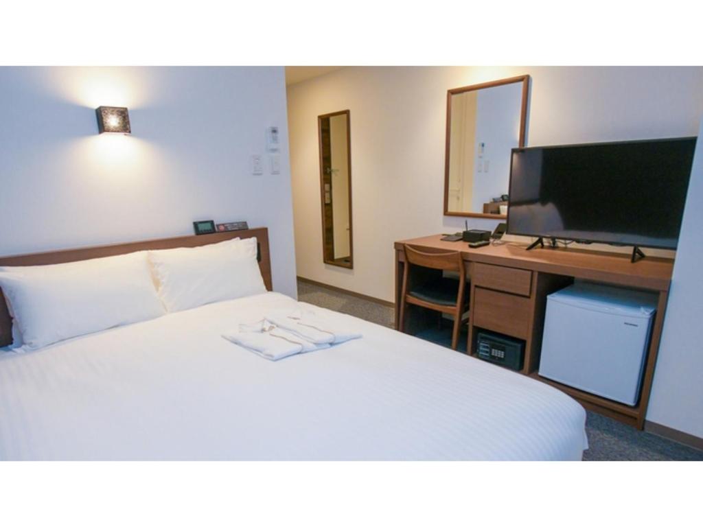 福冈ＹＯＵ ＳＴＹＬＥ ＨＯＴＥＬ ＨＡＫＡＴＡ - Vacation STAY 16027v的一间卧室配有一张床和一张书桌及电视