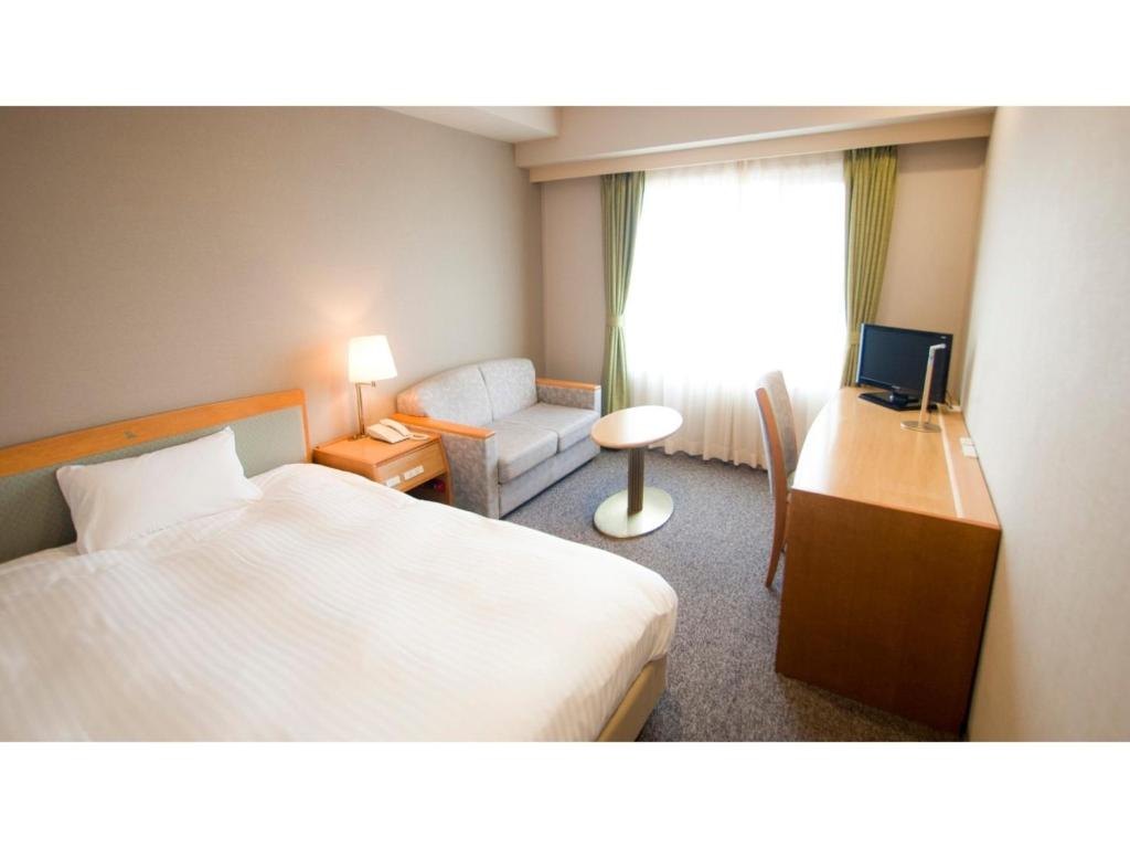赤穗Ako onsen AKO PARK HOTEL - Vacation STAY 21595v的酒店客房配有一张床、一张书桌和一张沙发。