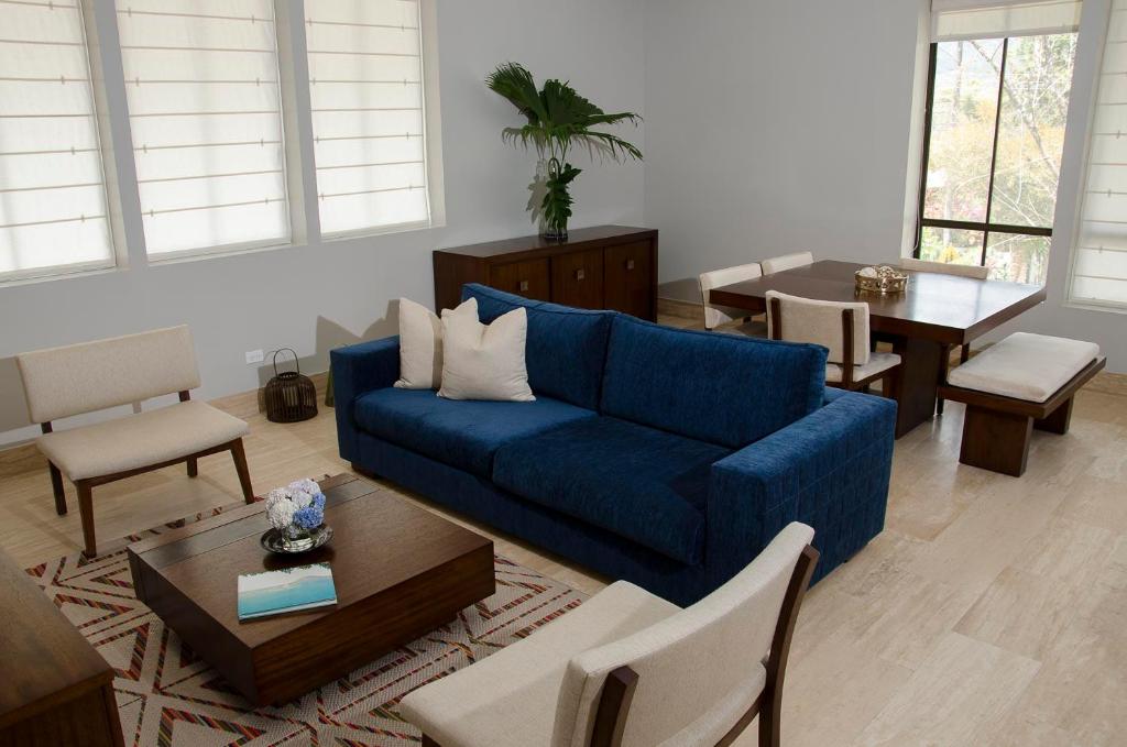 埃尔巴列德安通Paseo Suites El Valle, Luxury Apartments的客厅配有蓝色的沙发和桌子