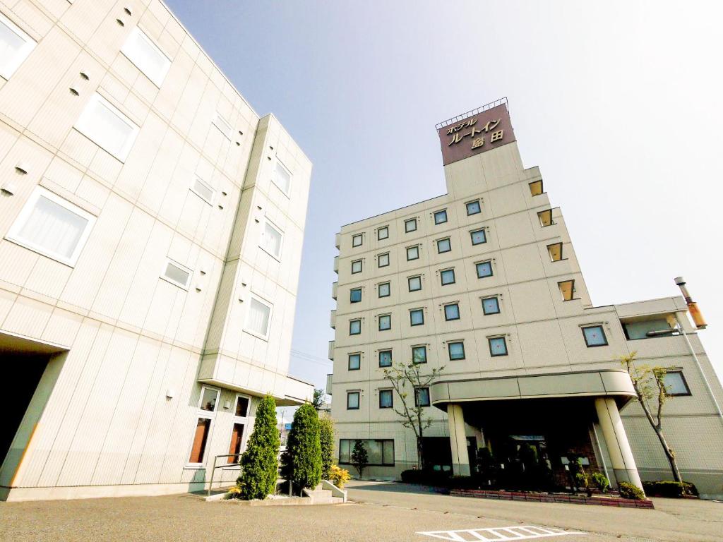 岛田岛田吉田国际鲁特因酒店的一座白色的大建筑,上面有时钟