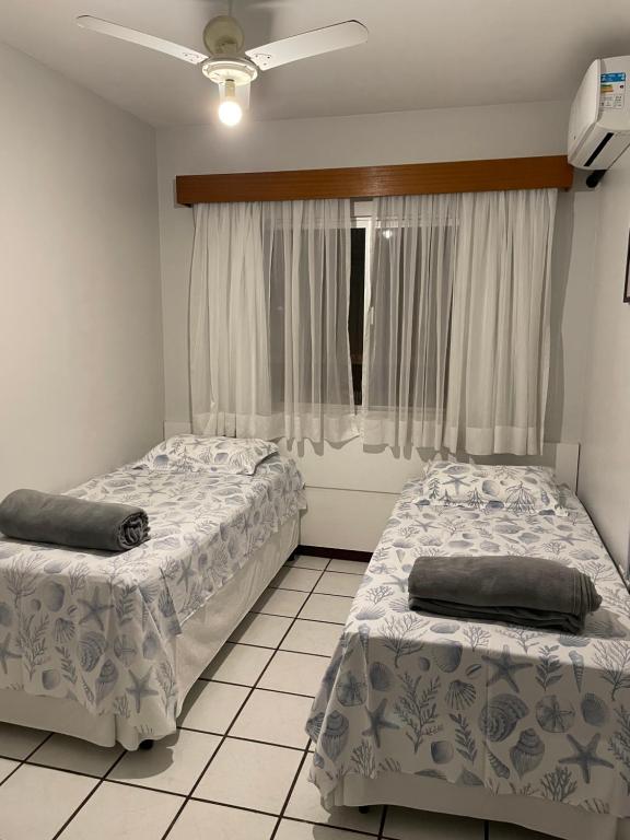巴拉奈里奥-坎布里乌Apartamento amplo e completo no centro Balneário Camboriú的带窗户的客房内的两张床