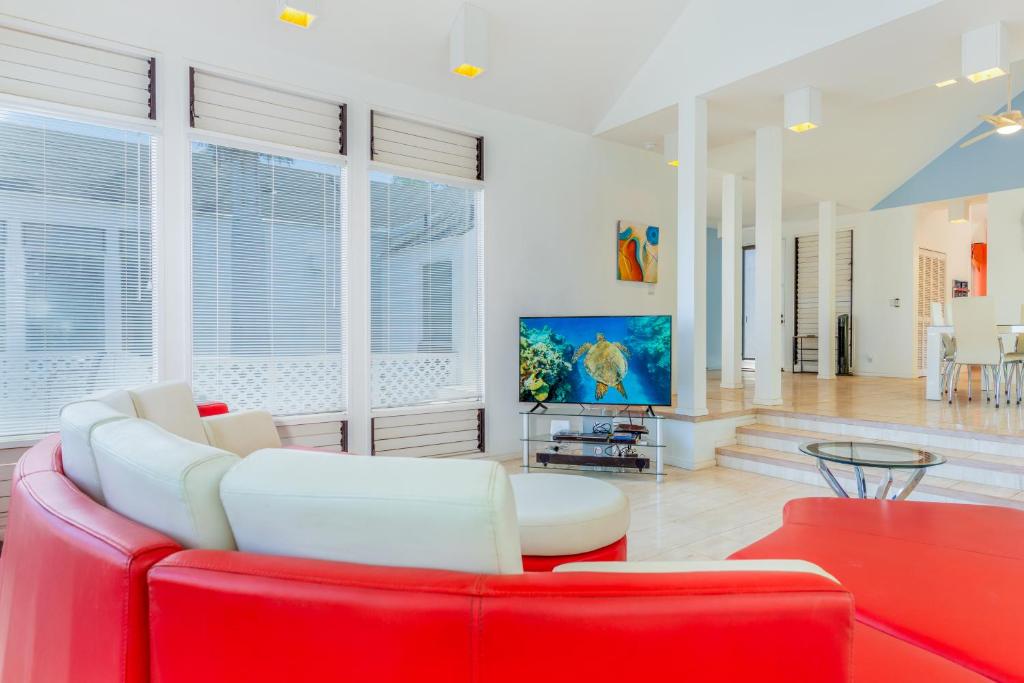 瓦克拉The H-House的客厅配有红色沙发和电视