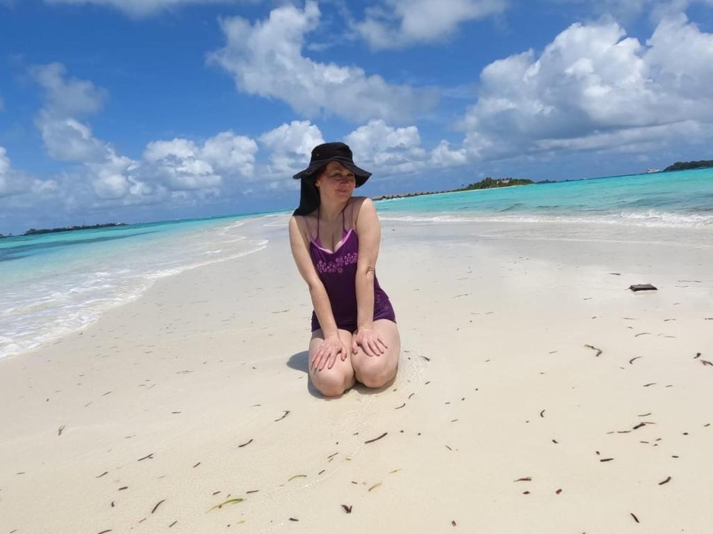 古雷德胡La Isla Tropica的坐在海滩上的年轻女人