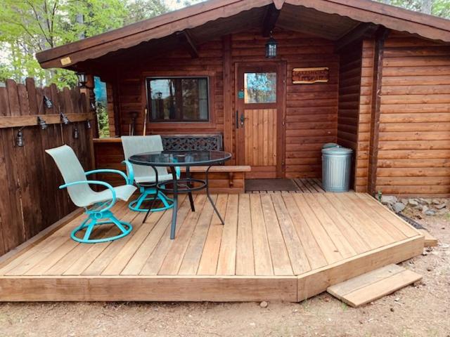 海沃德Lakeshore Lily Pad的小屋前的木甲板上配有桌椅
