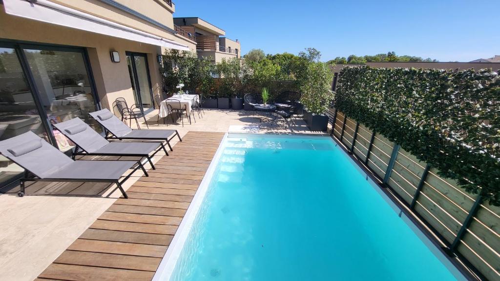 孔卡Villa 4 chambres piscine privée à 400m de la plage dans une résidence neuve的一座房子旁带躺椅的游泳池