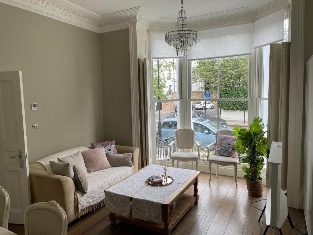 伦敦Stylish 3-bedroom flat in Kensington的客厅配有沙发和桌子