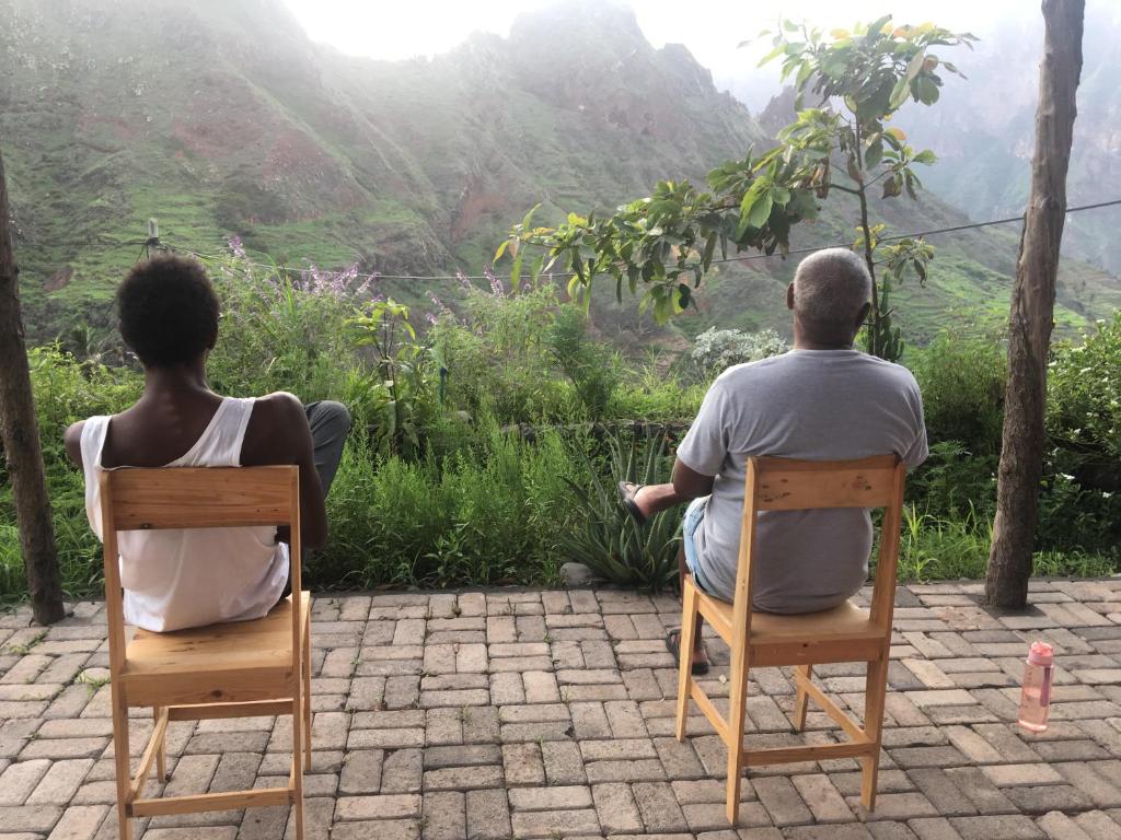 CaculiPousada Rural Simpatia的坐在椅子上的男人和女人,看着山