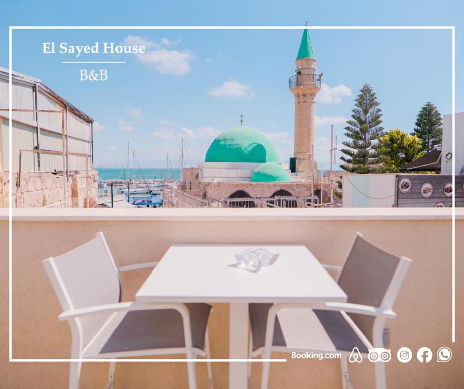 阿卡El Sayed House b&b的一个带清真寺的阳台的白色桌椅