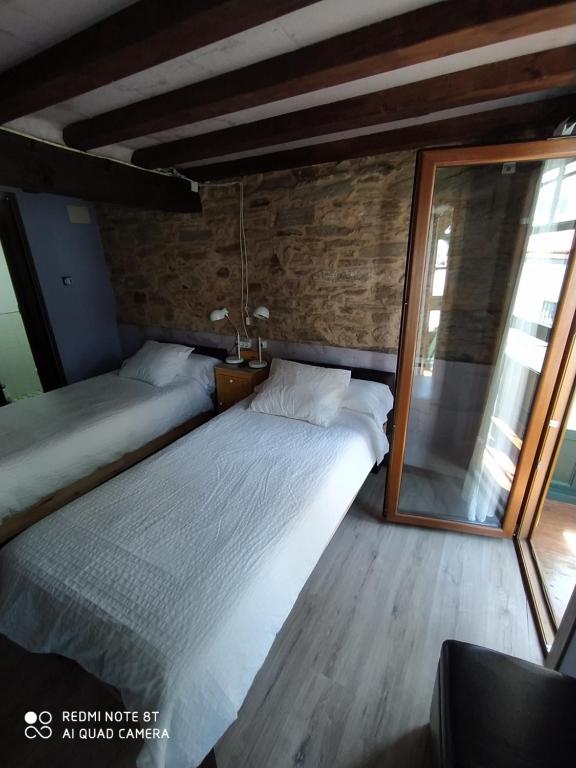 蓬特德乌梅Casa Apilladeira的一间卧室设有两张床和大镜子
