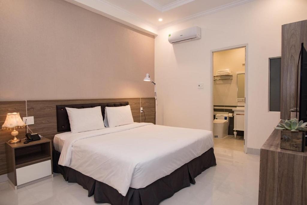 头顿Amora Hotel & Apartment的一间带白色大床的卧室和一间浴室