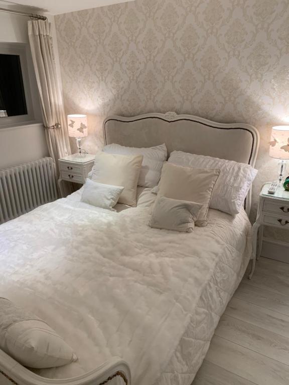 滨海纽比金Coastal Joy - Room 4的卧室内的一张带白色床单和枕头的床