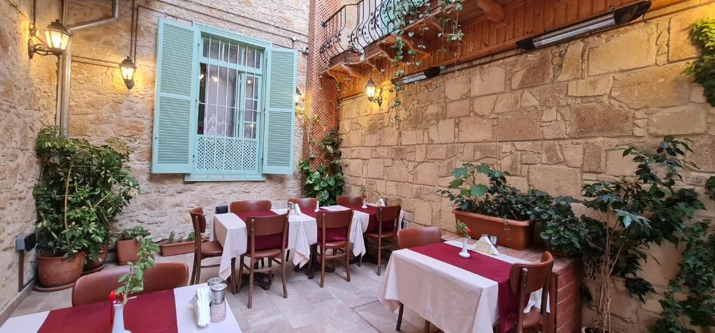 北尼科西亚Hotel Valide Hanim Konak的一间带桌椅的餐厅以及砖墙