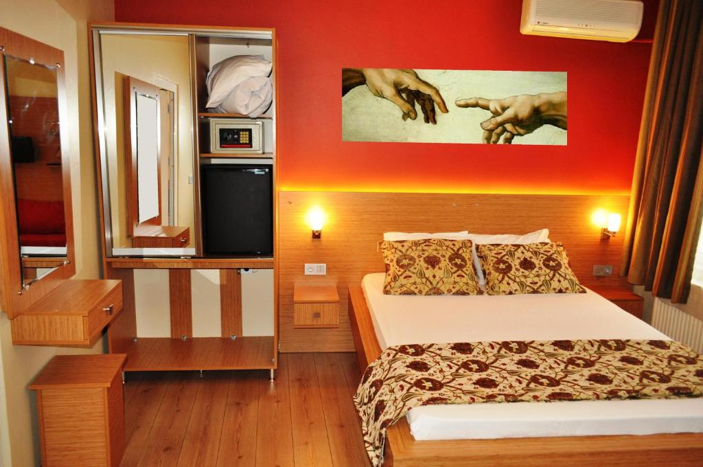 伊斯坦布尔古董酒店的一间卧室设有一张床和红色的墙壁