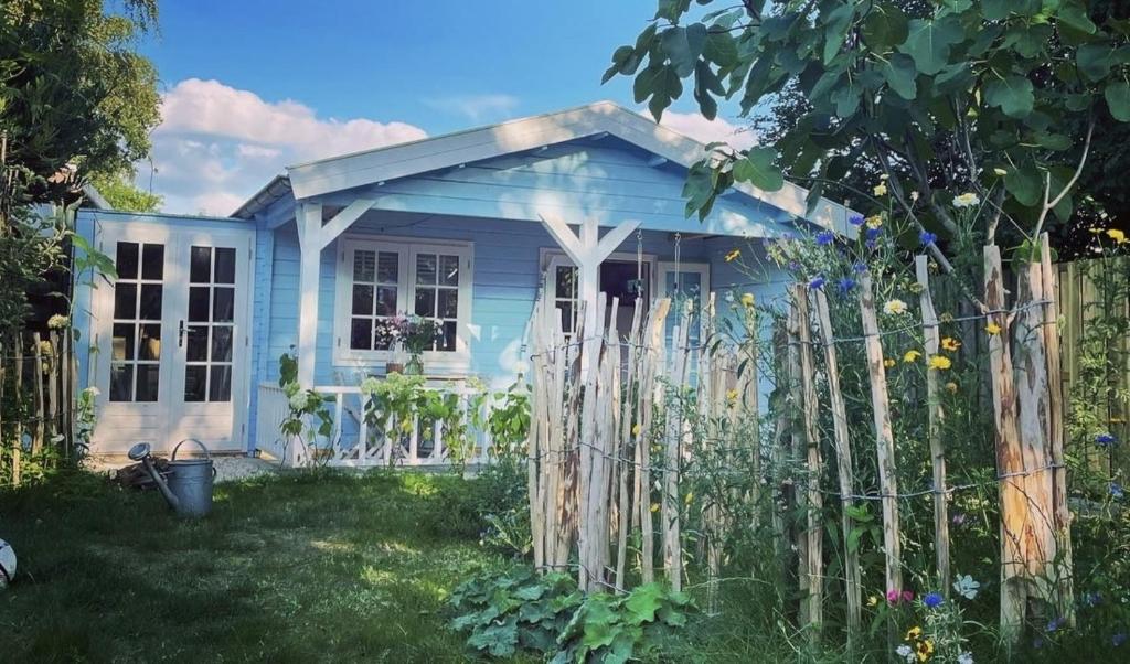 海尔德罗普Bed and breakfast de Heg的院子中带围栏的小蓝色房子