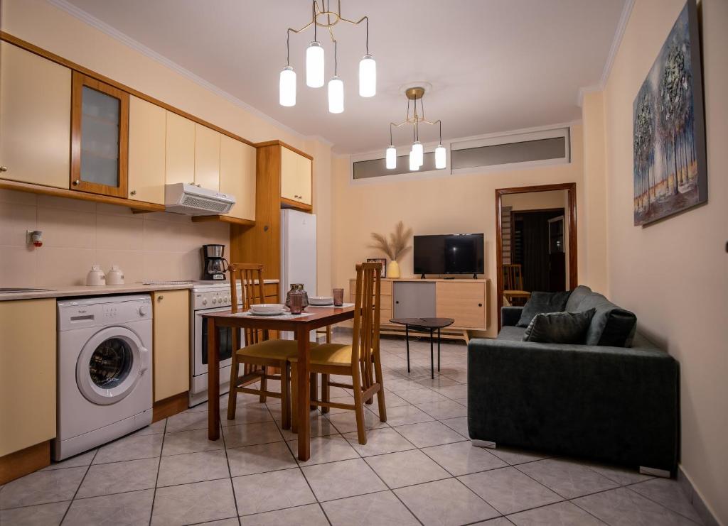 萨摩斯Ariadni Luxury Apartment的厨房以及带桌子和沙发的客厅。