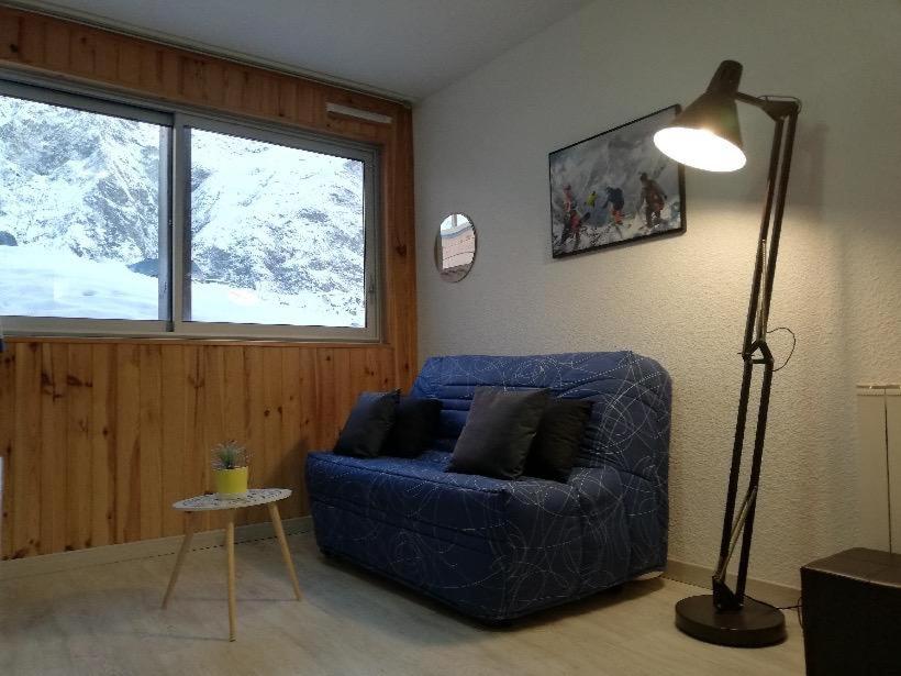 阿拉纽埃Ski Piau engaly 50 m des pistes de ski et du cœur de station的客厅配有蓝色的沙发和灯具
