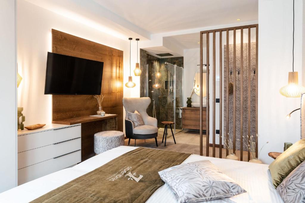 利莫内-苏尔加达Sibenbras Natural Aparthotel的一间卧室配有一张带电视和书桌的床。