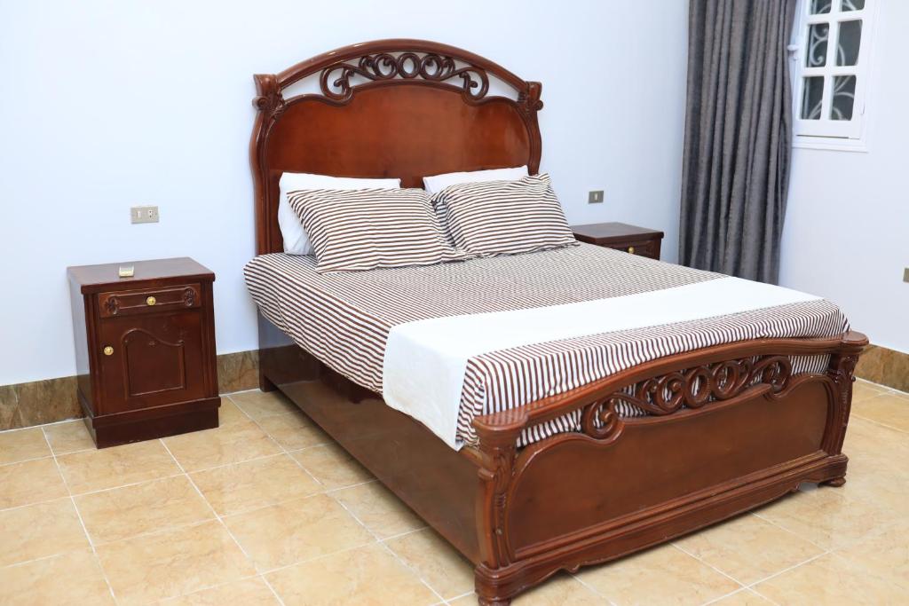 卢克索满月之家公寓的一间卧室配有一张带木架和枕头的床。