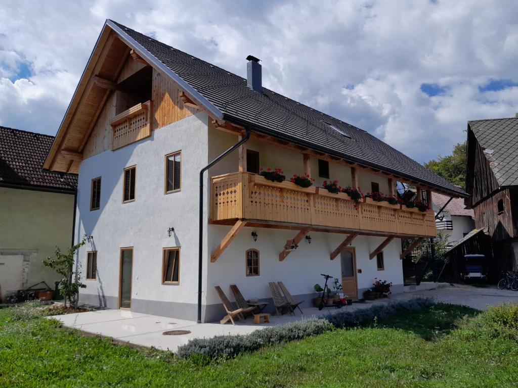 布莱德Turistična kmetija Grabnar的带阳台和两把椅子的白色房屋