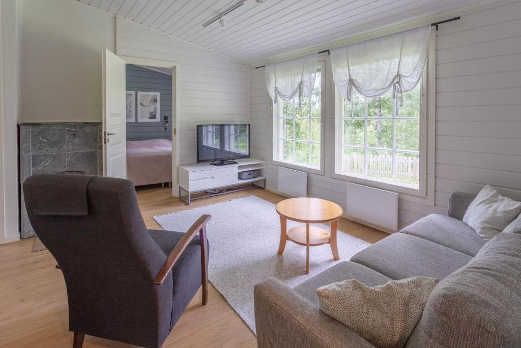 卡亚尼Lomaperkkiö Cottages的带沙发和电视的客厅