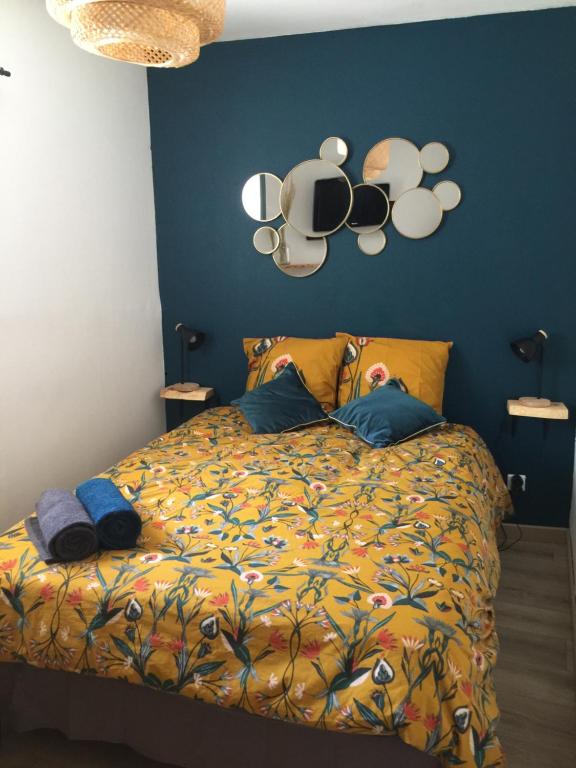 AiguilheLe Georges的一间卧室配有一张带彩色被子和镜子的床。