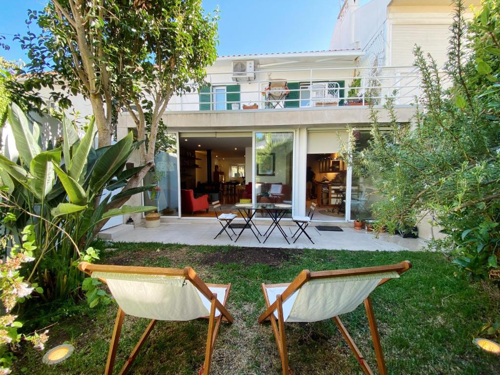 里斯本Casa das Boganvilias - Moradia com jardim的房子院子内的两把椅子