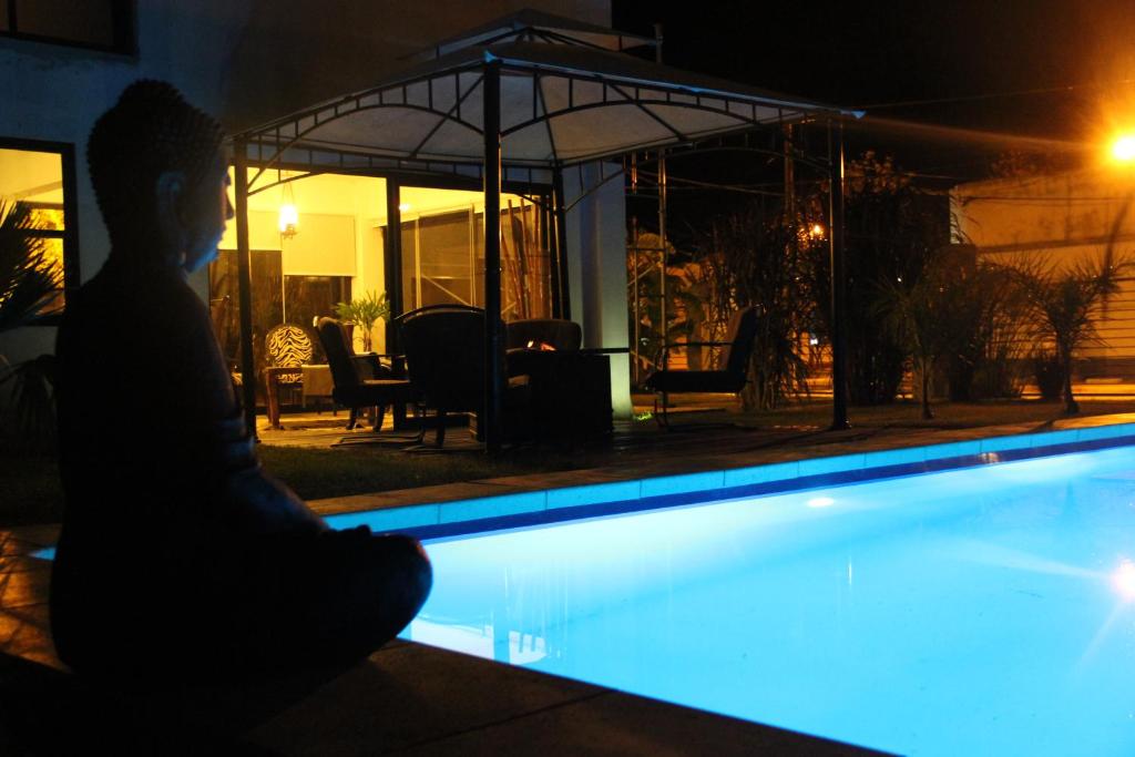 圣格雷戈里奥德波兰科Bali Hotel Boutique的坐在游泳池旁的男人
