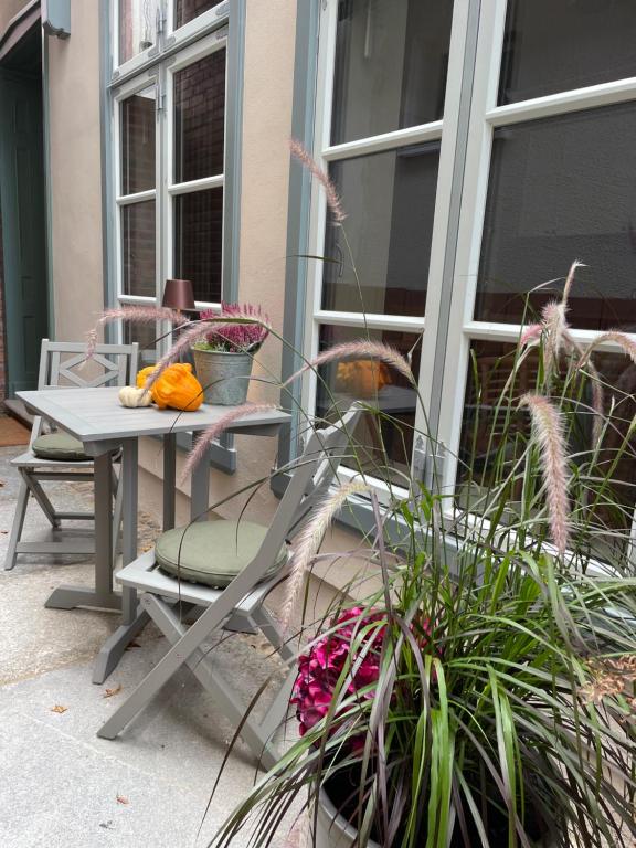 瓦尔内明德Warnemünde: Apartment KAJÜTE - nur 3 Gehminuten zum Strand的庭院配有桌椅和植物