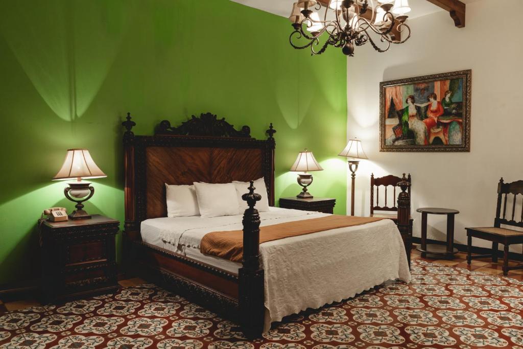 格拉纳达格兰弗朗西亚餐厅酒店的一间卧室配有一张带绿色墙壁和吊灯的床。