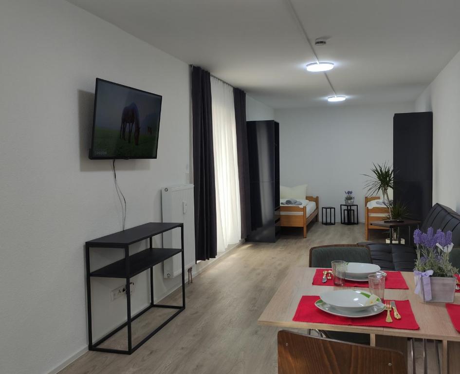 戈特马丁根2 Zimmerwohnung in Bietingen的客厅配有桌子,墙上配有电视