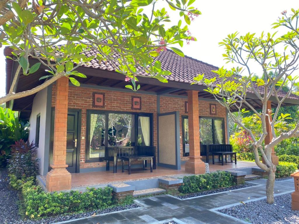 佩母德兰巴厘岛佩母得兰巴迪尼旅馆的一个小房子,设有门廊和桌子