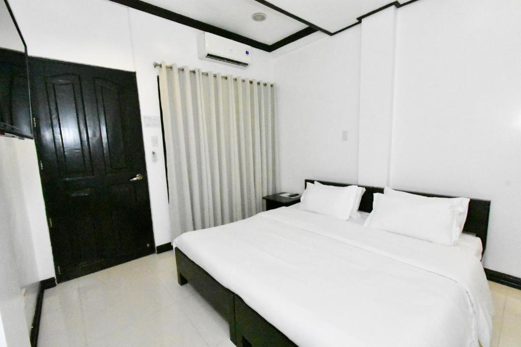 爱妮岛金丝燕酒店 的卧室配有白色的床和黑色的门
