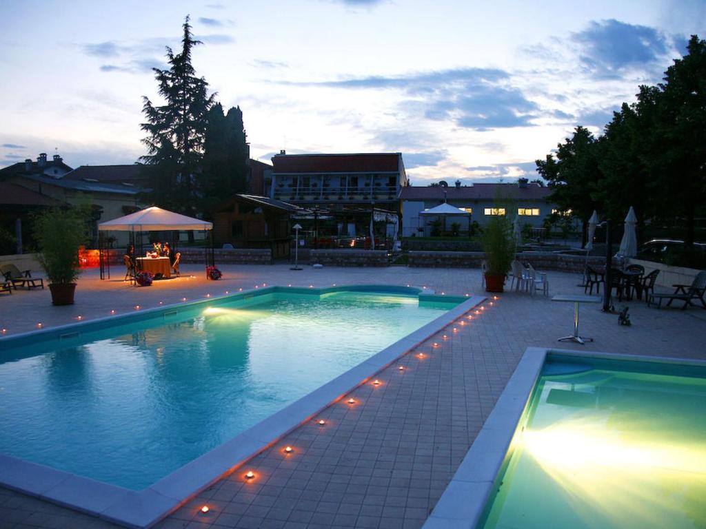维瓦罗格林度玛格里蒂农家乐的庭院中带灯光的大型游泳池
