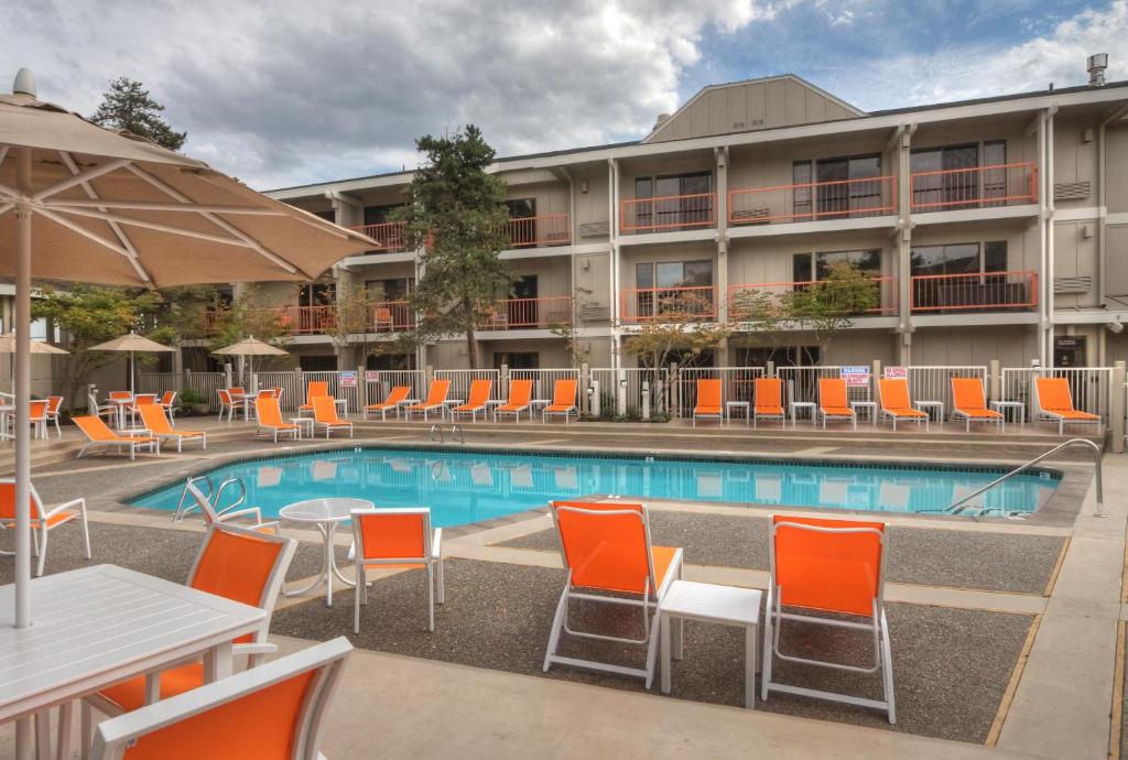 阿什兰阿什兰山套房酒店的酒店设有一个游泳池,配有橙色的椅子和桌子